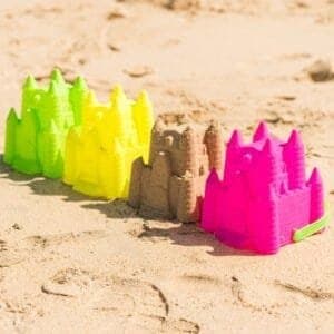 Kleurrijke zandcastles en zandbak speelgoed op het strand.