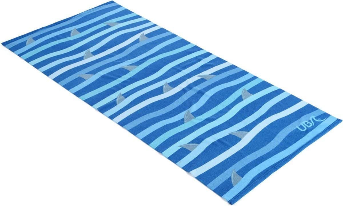 Blue striped beach mat with shark detail, perfect for outdoor leisure activities.