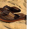 Sandals for outdoor use with leather look on sandy beach.