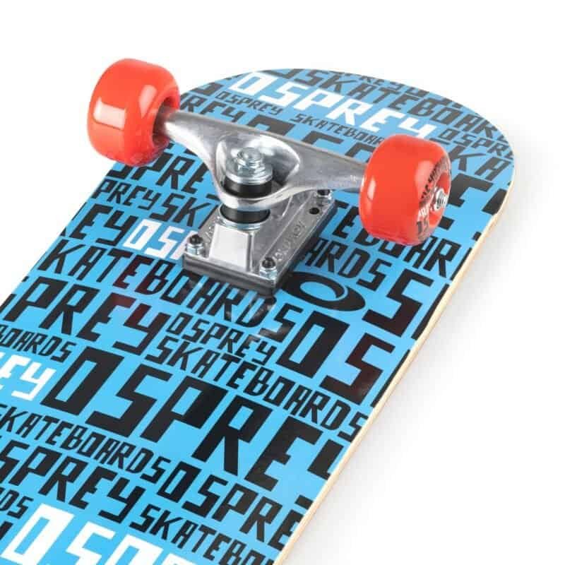 Kleine skateboard met blauwe en zwart print, glanzende trucks en rode wielen.