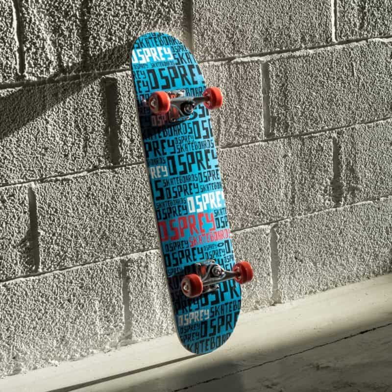 Skateboard met blauwe en rode branding, hangend aan een betonnen muur.