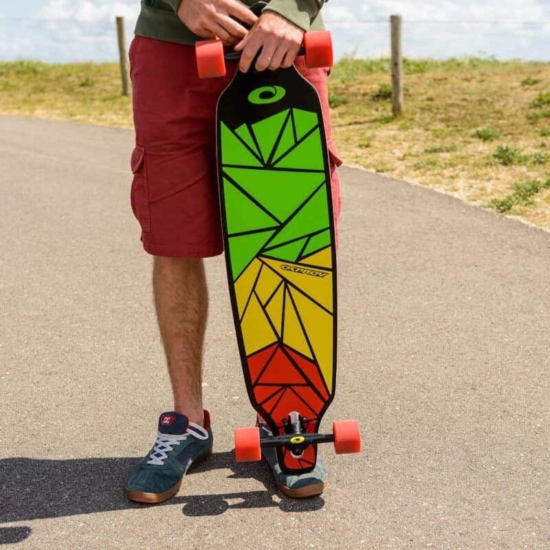 Kleurige longboard met geometrisch ontwerp en rode wielen voor buitenplezier.