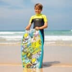 Habillez-vous avec une combinaison et une planche de surf sur la plage.