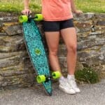 Skateboard aux motifs bleus vibrants et aux roues vertes fluo, prêt pour des balades relaxantes en plein air.