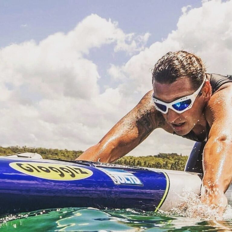 Man met Glogglz zonnebril peddelt op een board.