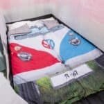 Skateboard bedding with car logos and colourful details for outdoor fun.