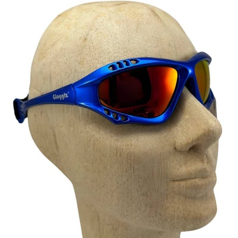 Goggles for skiing and snowboarding, blue with orange mirror lenses, on wooden mannequin.