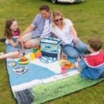 Gezellige familiedag met picknick op het gras, genieten van lekker eten en samen plezier maken.