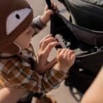 Laatstijl een kind ziet in een tas met een speelgoedspoorweg.