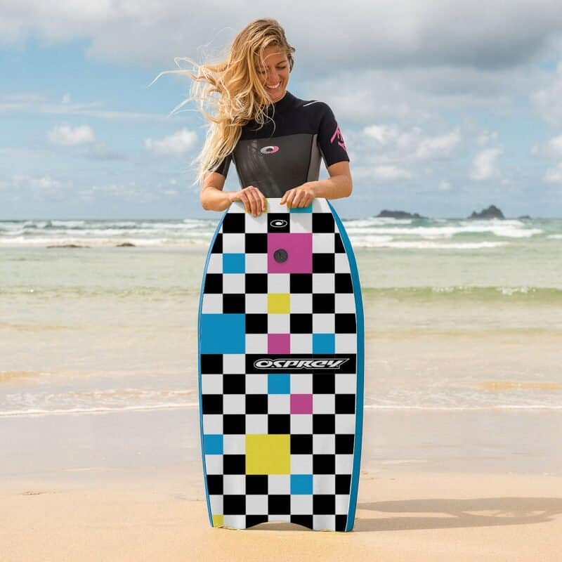 Kleurrijke surfplank met geometrisch patroon op het strand.