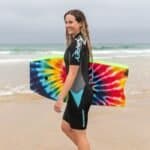 Paire de vêtements de surf et combinaison pour femmes sur la plage, prêtes à surfer.