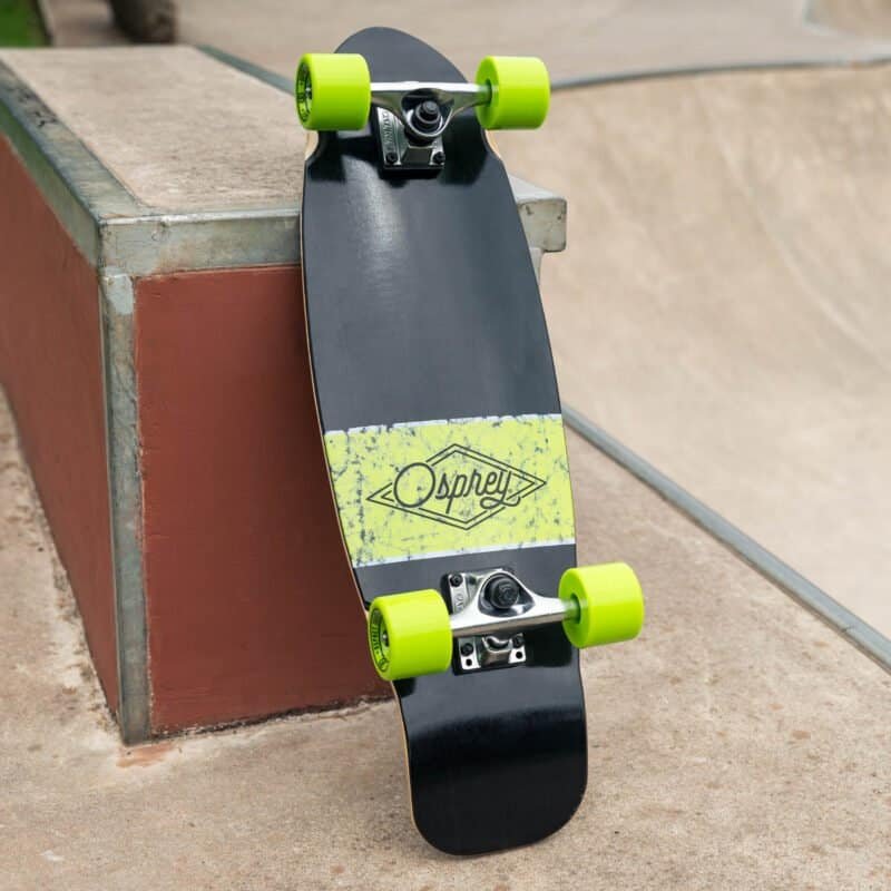 Skateboard met groen-witte wielen op een skatebaan, gericht op het deck met Osprey logo.