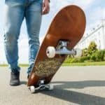 Skateboard met houten deck en white wielen op straat, close-up.