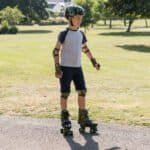 Inline skates, veiligheidsuitrusting en een jonge jongen die plezier heeft buiten.