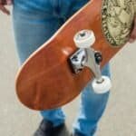 Vintage houten skateboard met witte wielen en metalen trucks voor outdoor skateboarden.