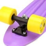 Small skateboard with yellow wheels and purple bottom, perfect for outdoor fun.
