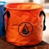 Petit sac isotherme orange fluo avec sangle de transport et logo Wave Classic, idéal pour les activités de plein air.