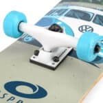Skateboard UFO avec roues bleues et logo VW sur la planche, prêt pour l'aventure en plein air.