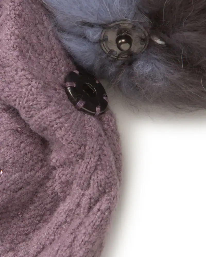 Kuscheliger grauer flauschiger Knopf mit schwarzem Knopf und Sportbekleidung in Großaufnahme.