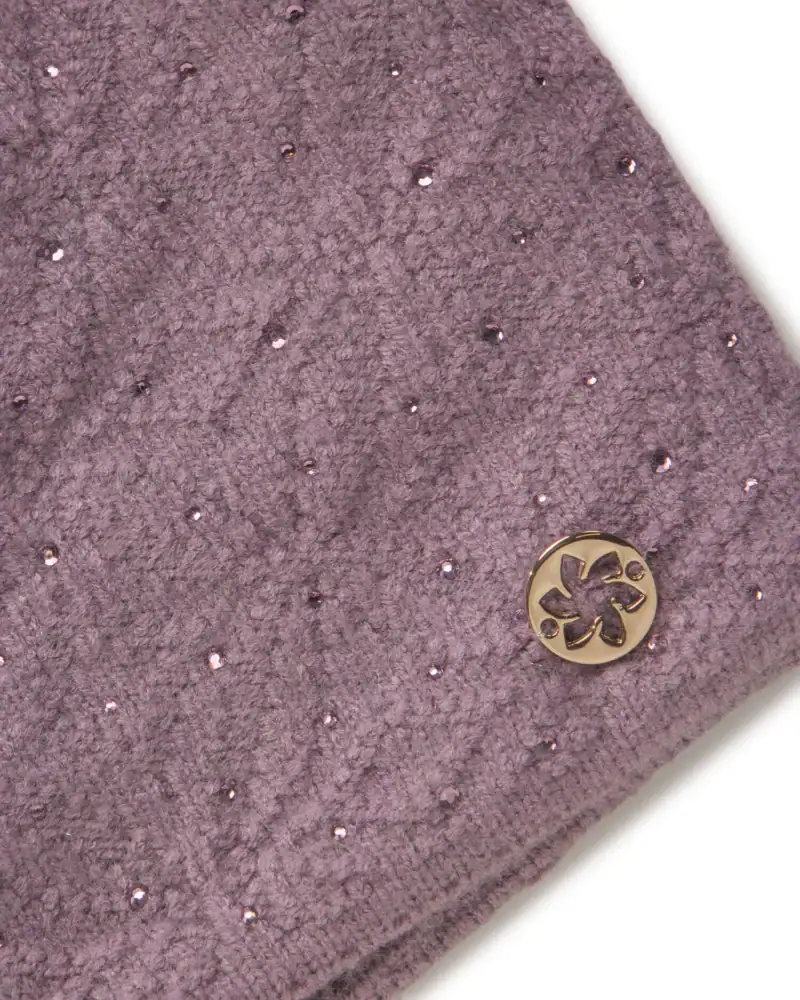Glitzerndes mauvefarbenes Fleece mit silbernen Details und einem Logo-Pin aus Metall.