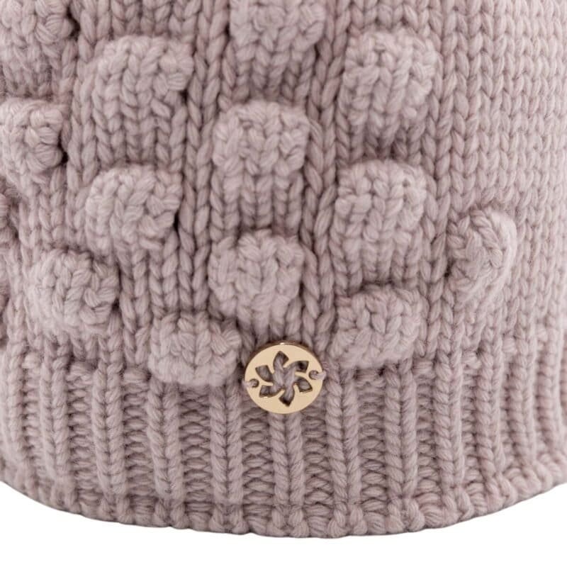 Knitted wool hat with pom-poms and metallic logo detail.