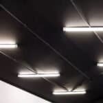 Verlichte plafond met donkere plafondpanelen en LED-verlichting bij Winkel van Hugo.
