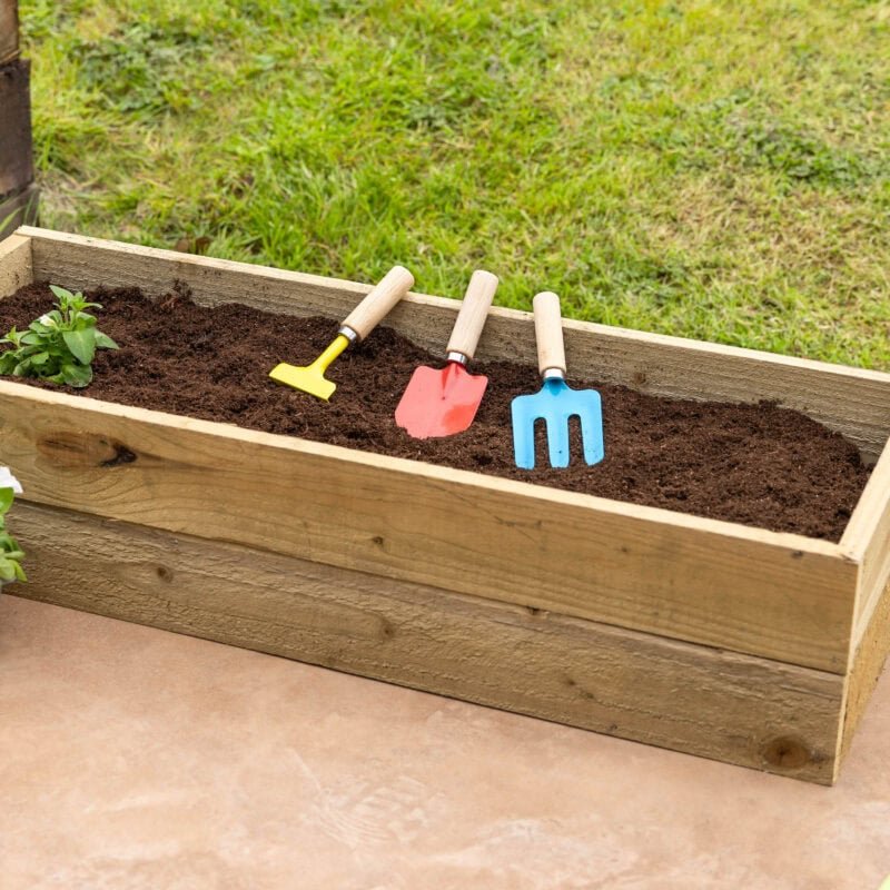 Outils de jardin colorés dans une jardinière en bois pour le jardinage.