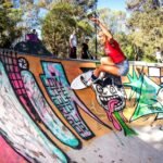 Artful skateboarding on a graffiti track in a park.